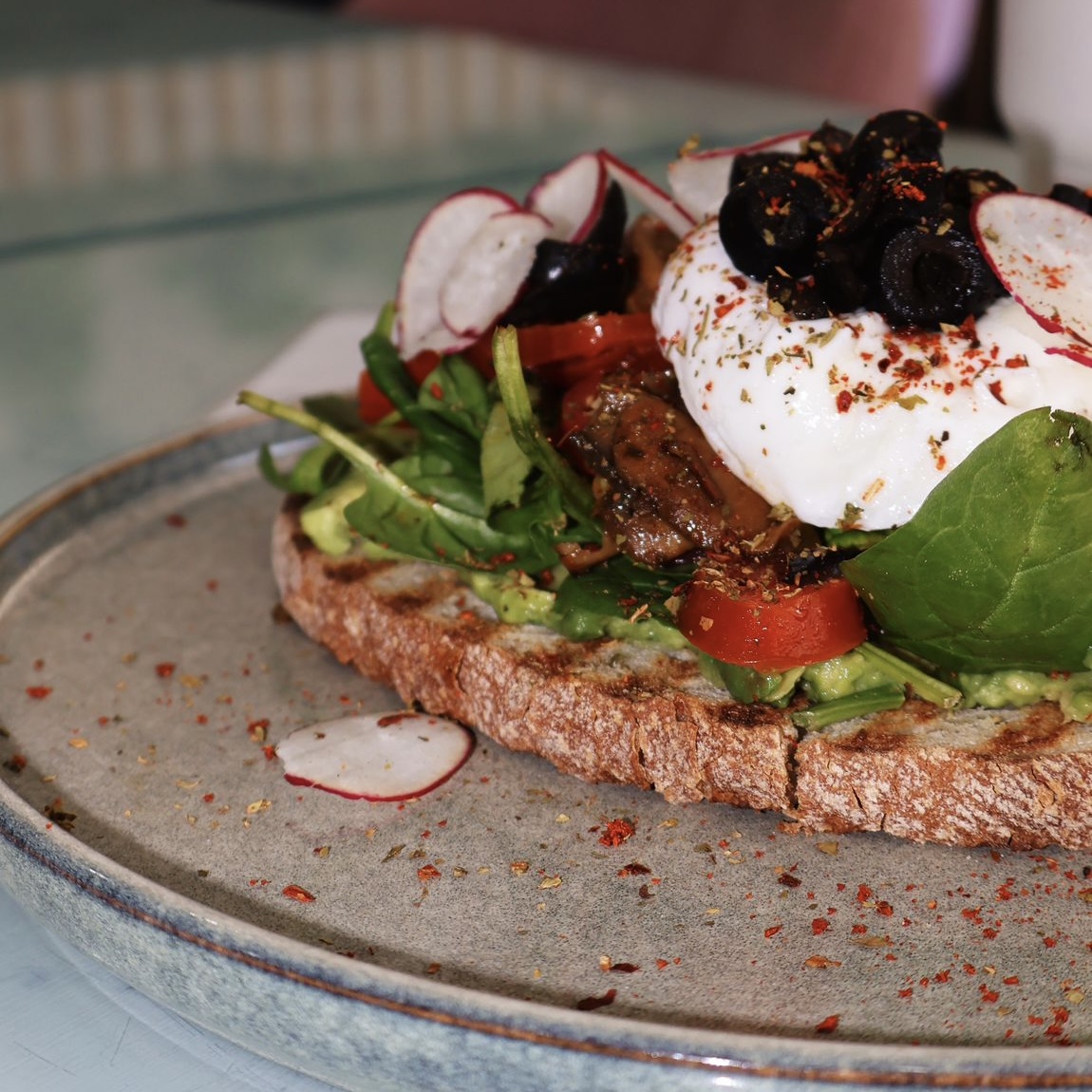 Mafra bread, poached egg, guacamole, cherry tomato, fresh mushrooms, radishes, olives, spinach, spices